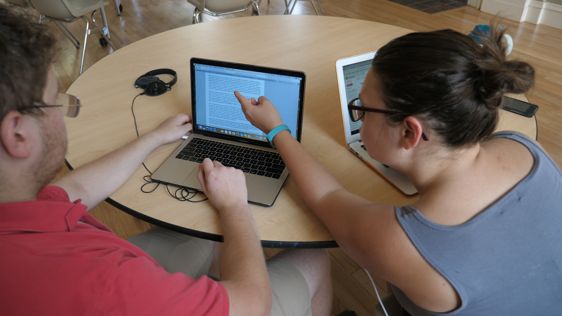 three people sitting in front of table laughing together