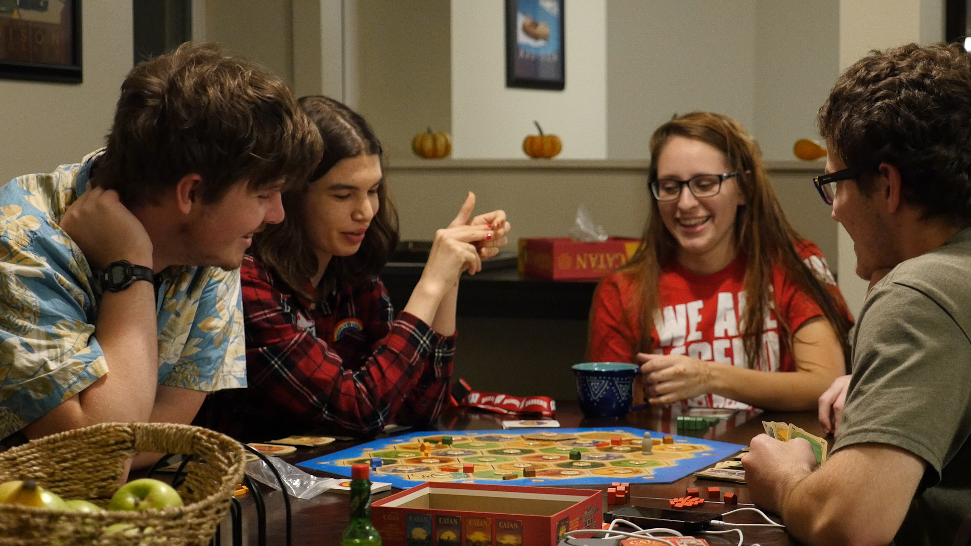 three people sitting in front of table laughing together