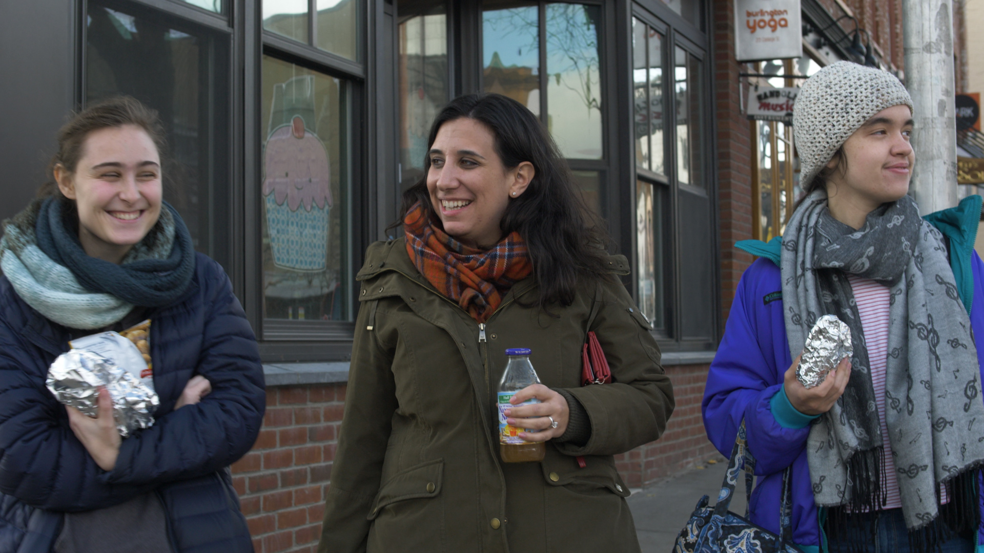 three people sitting in front of table laughing together
