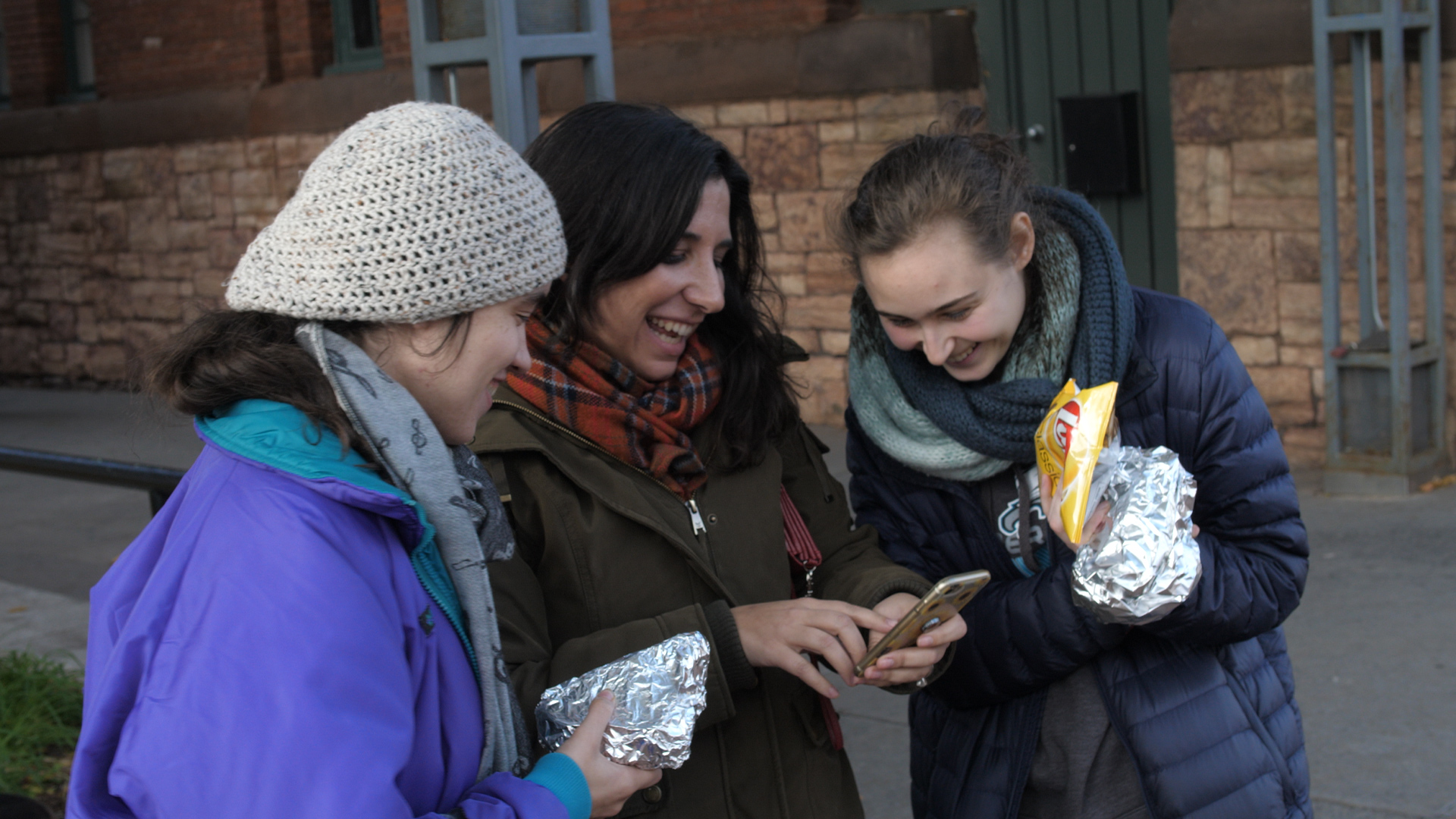 three people sitting in front of table laughing together