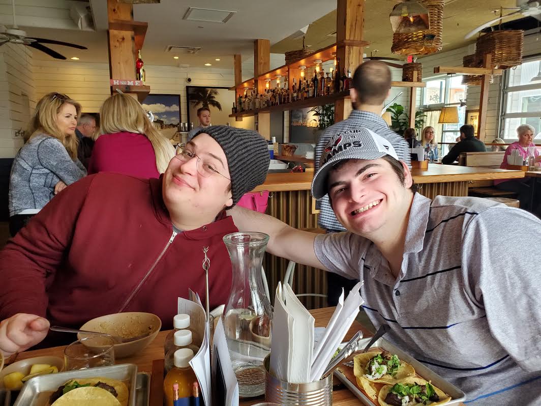 three people sitting in front of table laughing together