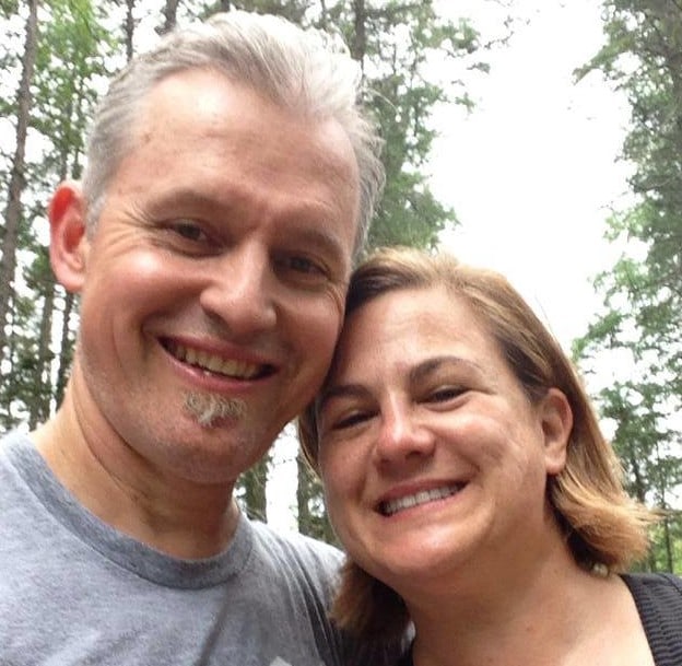 three people sitting in front of table laughing together
