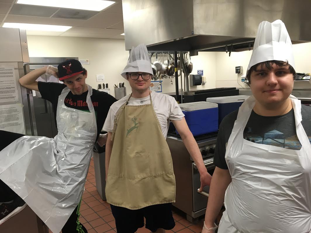 three people sitting in front of table laughing together
