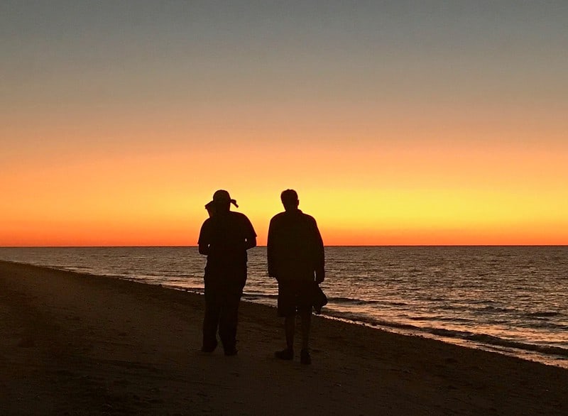 three people sitting in front of table laughing together