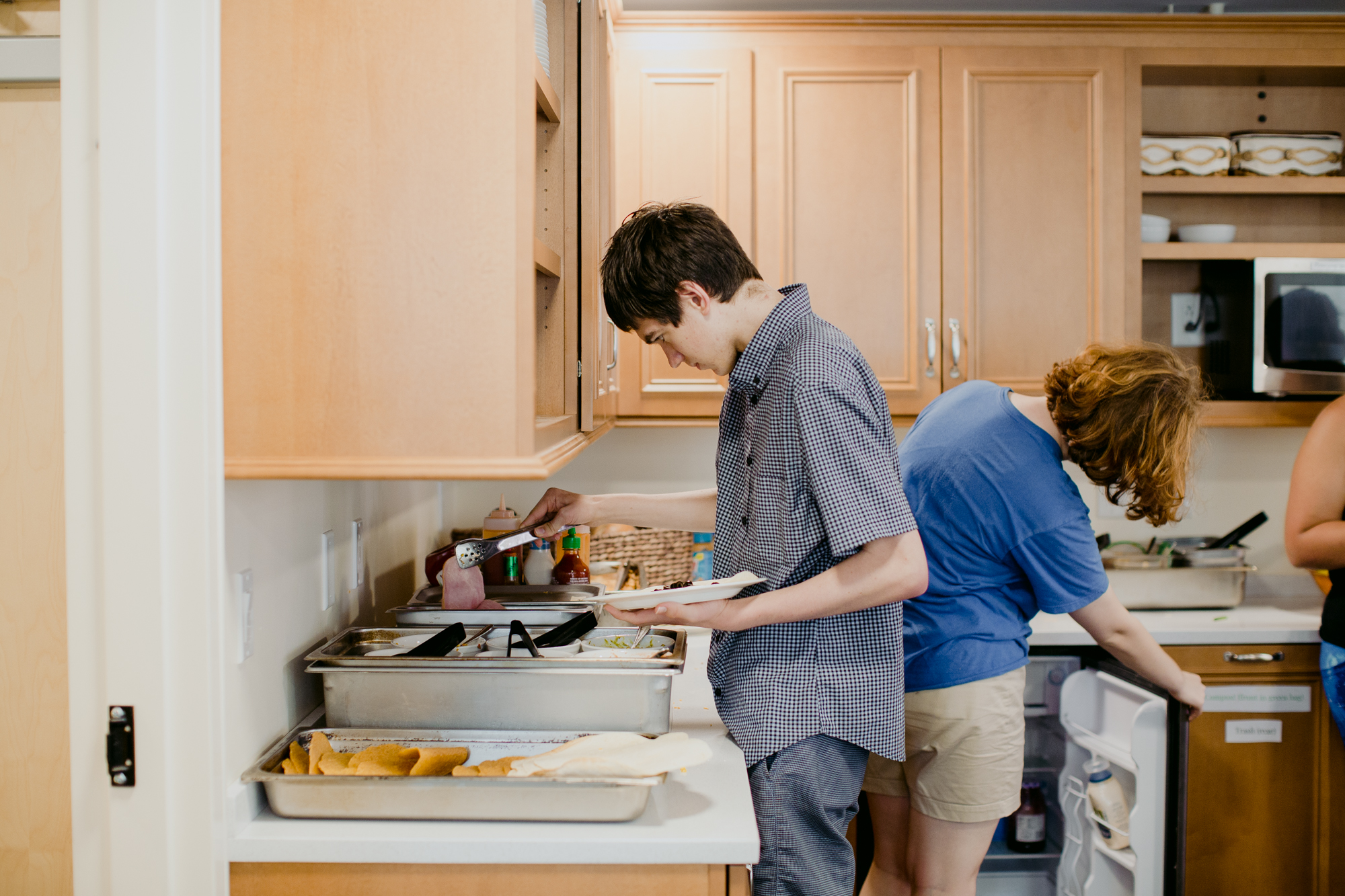 three people sitting in front of table laughing together