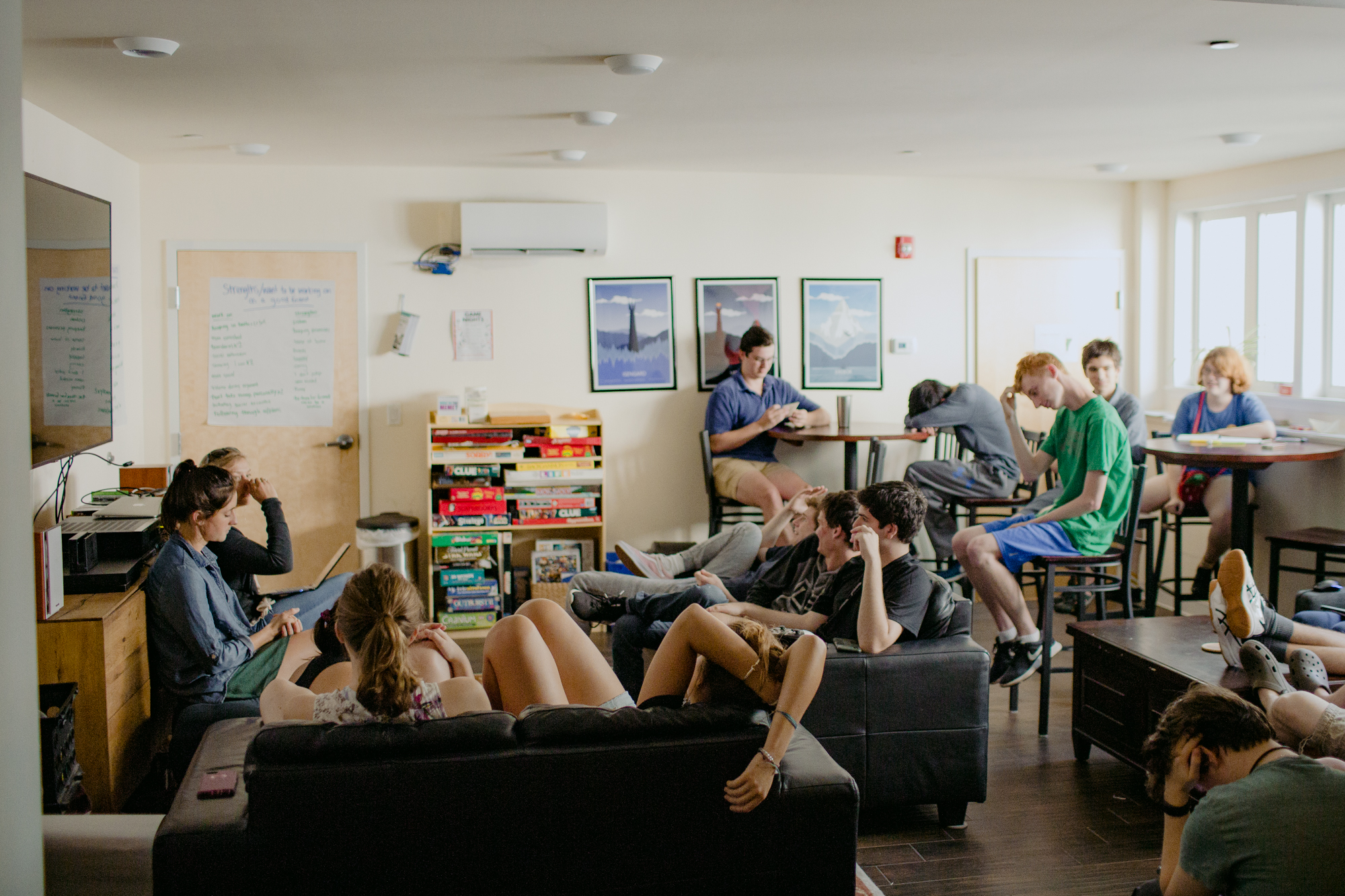 three people sitting in front of table laughing together