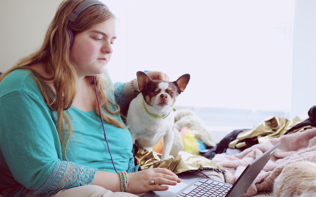 Student with autism doing school work with her dog