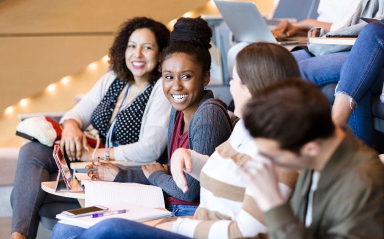 college students conversing in a lecture hall